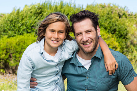 Father and son smiling at camera in the countrysideの写真素材