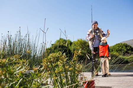 Happy man fishing with his son in the countryside