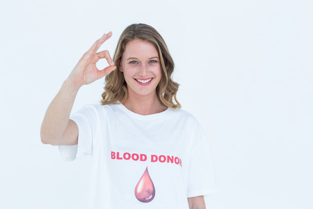 Blood donor showing okay sign on white backgroundの写真素材