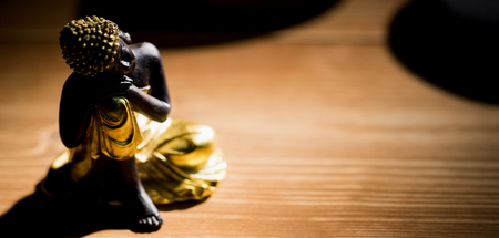 Wooden buddha statue on table shot in studioの写真素材