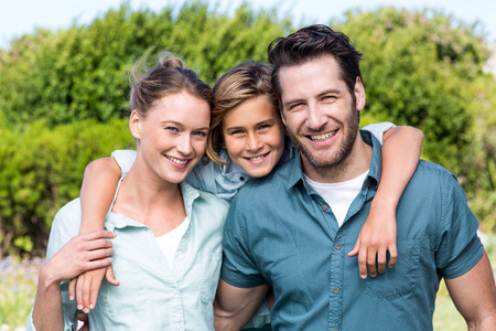 Happy family smiling at camera in the countrysideの写真素材