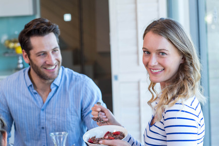Happy couple having breakfast together at home in the kitchenの写真素材