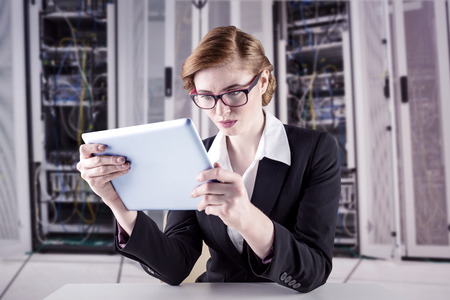 Redhead businesswoman using her tablet pc against data center
