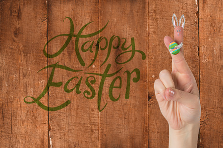 Fingers as easter bunny against wooden planksの写真素材