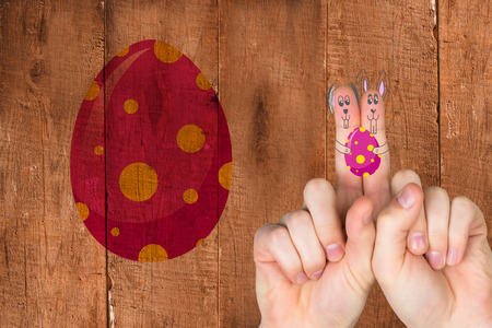 Fingers as easter bunny against wooden planksの写真素材