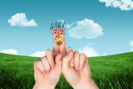 Fingers as easter bunny against blue skyの写真素材