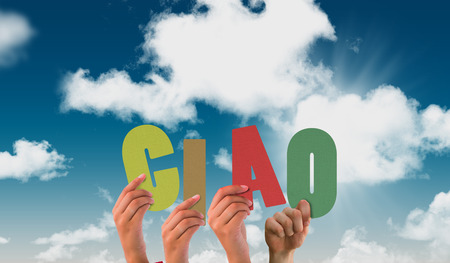 Hands holding up ciao against blue skyの写真素材