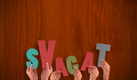 Hands holding up svagat against wooden oak tableの写真素材