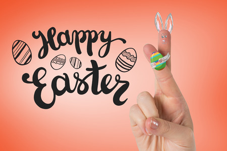 Fingers as easter bunny against orangeの写真素材