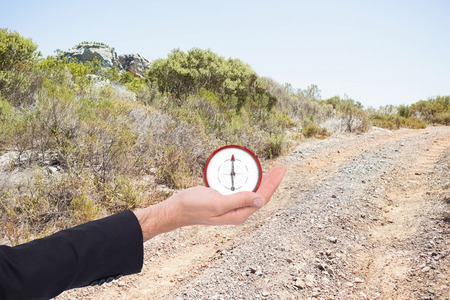 Close up of businessman with empty hand open against mountain trailの写真素材