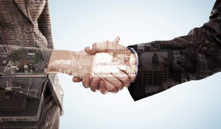 Close up of two businesspeople shaking their hands against new york