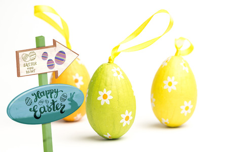 Easter egg hunt sign against three foil wrapped easter eggsの写真素材