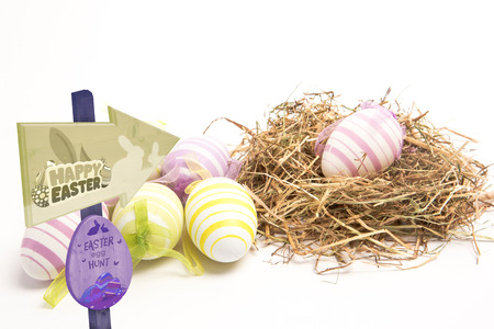 Easter egg hunt sign against easter eggs with straw