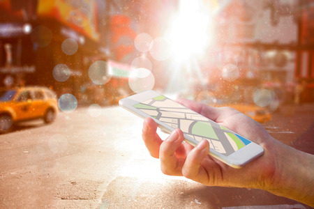 Man using map app on phone against blurry new york streetの写真素材