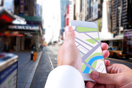 Man using map app on phone against blurry new york street
