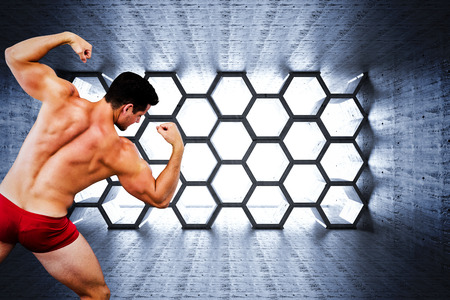 Attractive bodybuilder against hexagon roomの写真素材