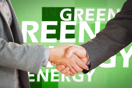 Two people having a handshake in an office against creative image of green energy conceptの写真素材