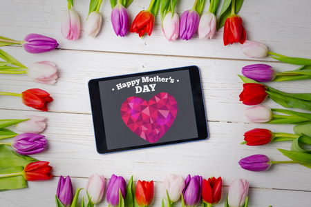 happy mothers day against tulips on deskの写真素材
