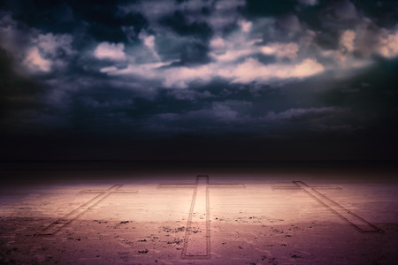 Cross against dark cloudy skyの写真素材