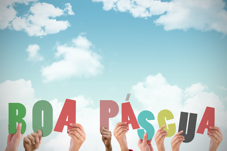 Hands holding up boa pasqua against blue skyの写真素材