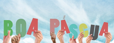 Hands holding up boa pasqua against blue skyの写真素材