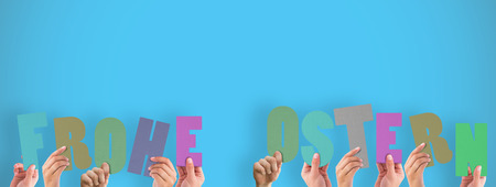 Hands holding up frohe ostern against blue background with vignetteの写真素材