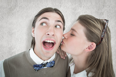 Pretty geeky hipster giving boyfriend kiss on the cheek against white backgroundの写真素材