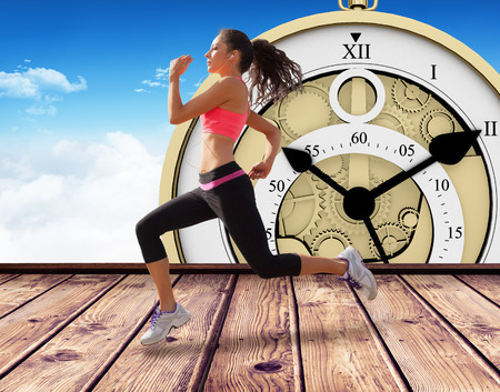 Full length of healthy woman jogging  against wooden planks against blue sky
