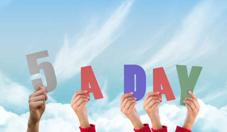 Hands holding up against blue skyの写真素材