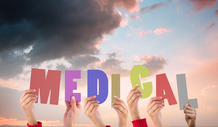 Hands holding up medical against orange and blue sky with cloudsの写真素材