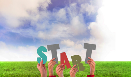Hands holding up start against green field