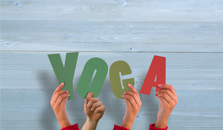 Hands holding up yoga against bleached wooden planks backgroundの写真素材