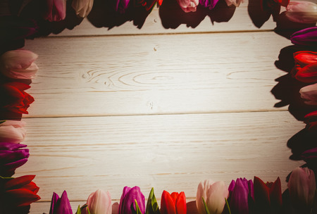 Tulips forming frame on wooden tableの写真素材