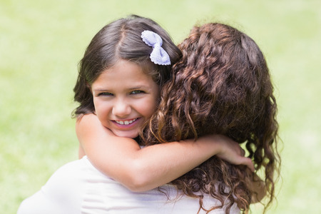 Happy mother and daughter hugging in the gardenの写真素材