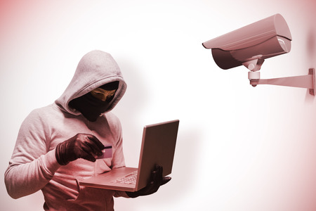 Hacker using laptop to steal identity against cctv camera