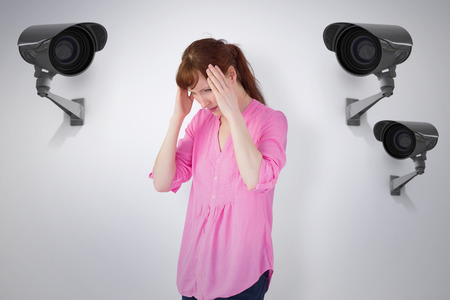 Worried redhead against cctv camera