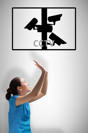 Young businesswoman pushing up against cctvの写真素材