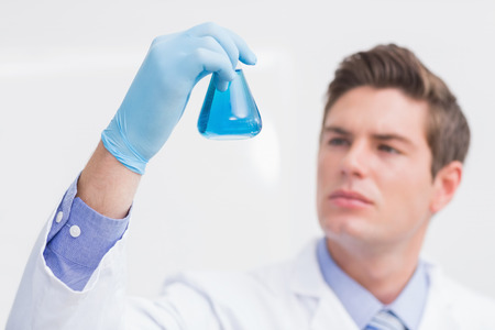 Scientist looking attentively at the beaker in laboratory
