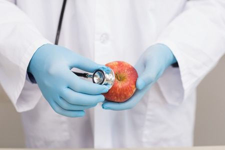 Scientist listening apple with stethoscope in laboratory