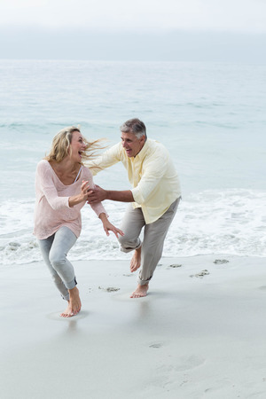 Happy couple having fun together at the beachの写真素材