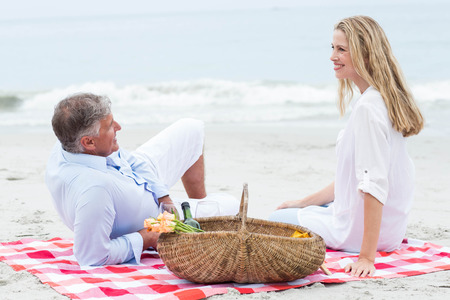 Happy couple having picnic at the beachの写真素材