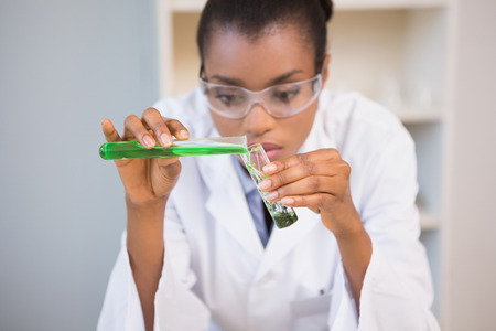 Concentrated scientist doing scientific experiment in laboratoryの写真素材