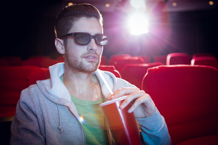 Young man watching a 3d film at the cinemaの写真素材