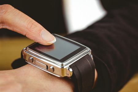 Businesswoman using her smart watch shot in studio