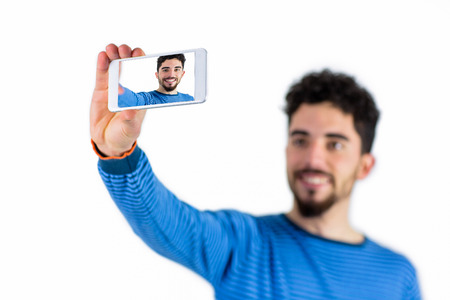 Casual man taking a selfie shot in studio