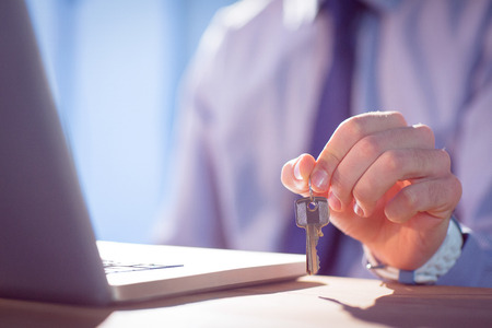 Businessman showing a key shot in studioの写真素材