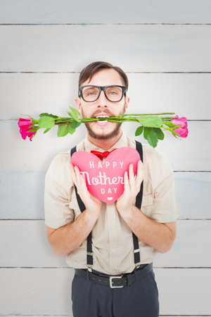 Geeky hipster offering valentines gifts against wooden planksの写真素材