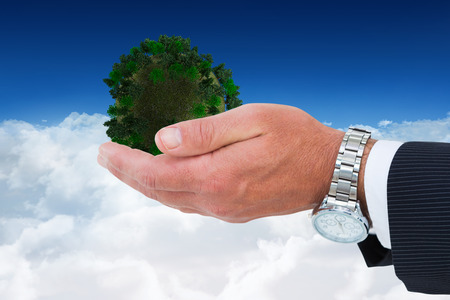 Businessman in suit offering handshake against bright blue sky over cloudsの写真素材
