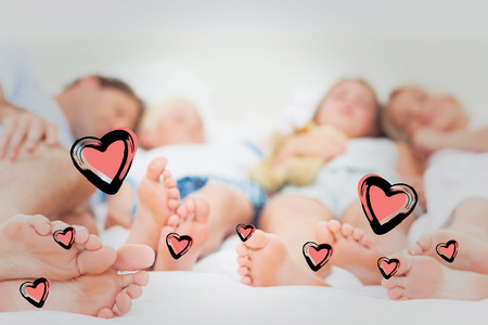 Close up of the feet of a family against red heartsの写真素材