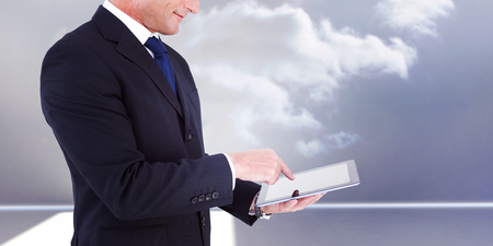 Mid section of a businessman with arms out against clouds in a roomの写真素材